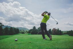 Golfer swinging on fairway (stock lifestyle)